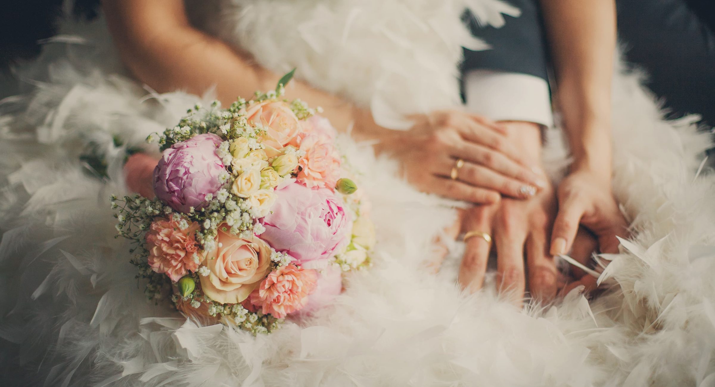 Newlyweds with close-up of bouquet